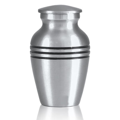 Small brass keepsake urn with a soft grey pewter finish and a rounded lift-off lid