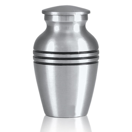 Small brass keepsake urn with a soft grey pewter finish and a rounded lift-off lid