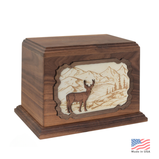 Wood cremation urn with a carved deer standing in relief, antlers cut clear of the panel