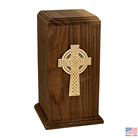 Walnut wood cremation urn with a detailed Celtic cross on the tall front panel