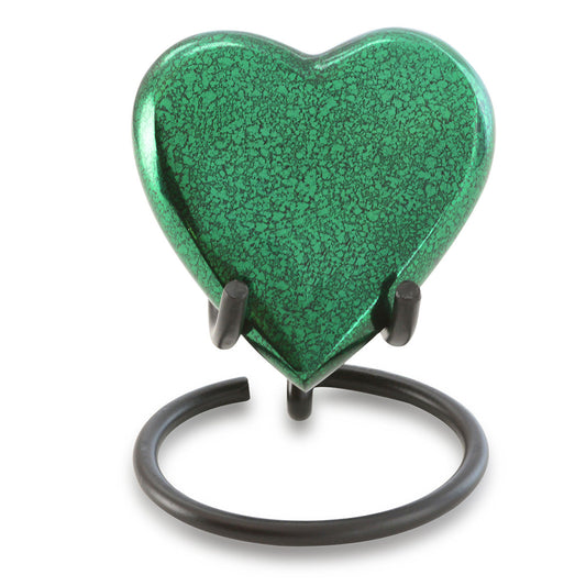 Small brass heart keepsake urn in a green finish standing on a matching base
