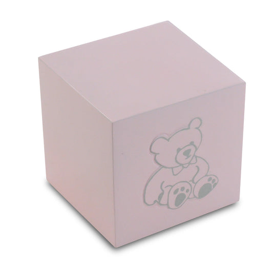 Pink cube-shaped infant cremation urn with a small teddy bear figure on the front panel
