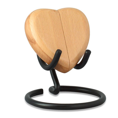 Pale wood heart-shaped keepsake urn standing upright on a flat base