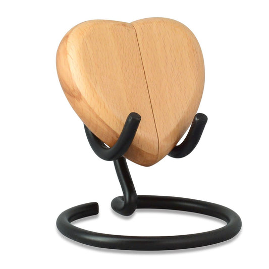 Pale wood heart-shaped keepsake urn standing upright on a flat base