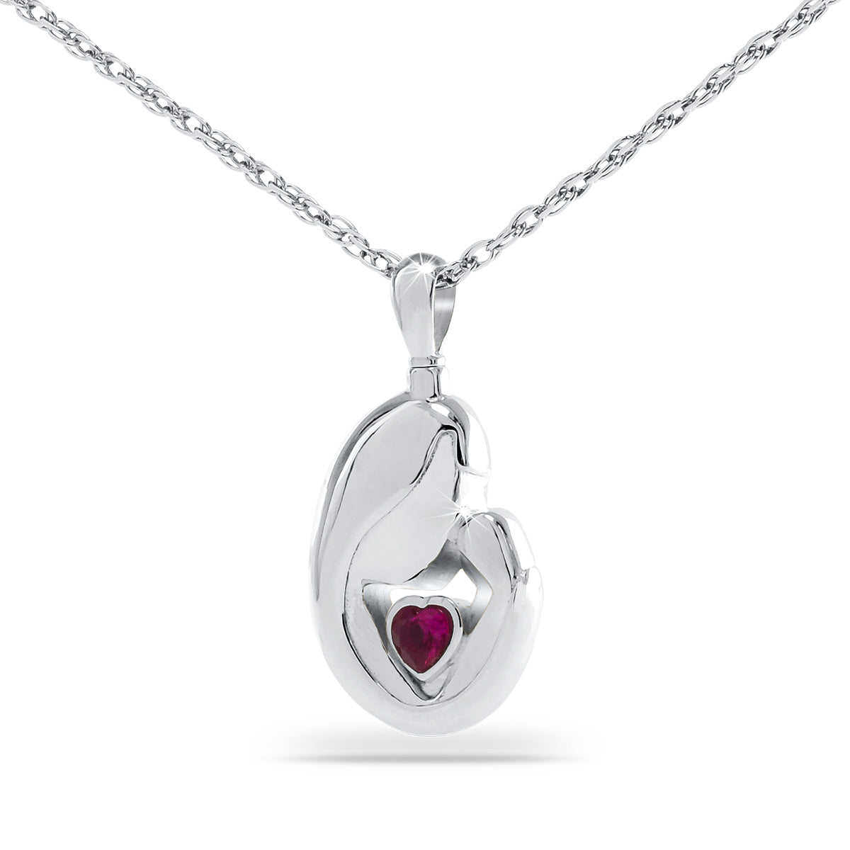 Silver pendant one inch tall with a red stone set at the front and a small side opening