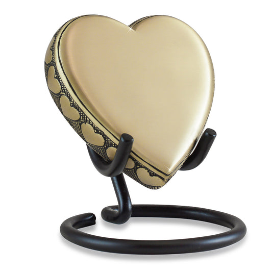 Flat brass heart keepsake urn lying almost level, plain polished front face