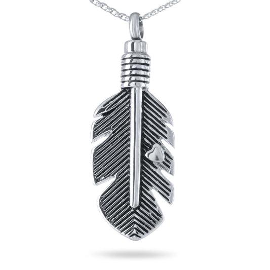 Wide stainless steel feather pendant lying almost horizontal with barbs cut into the metal
