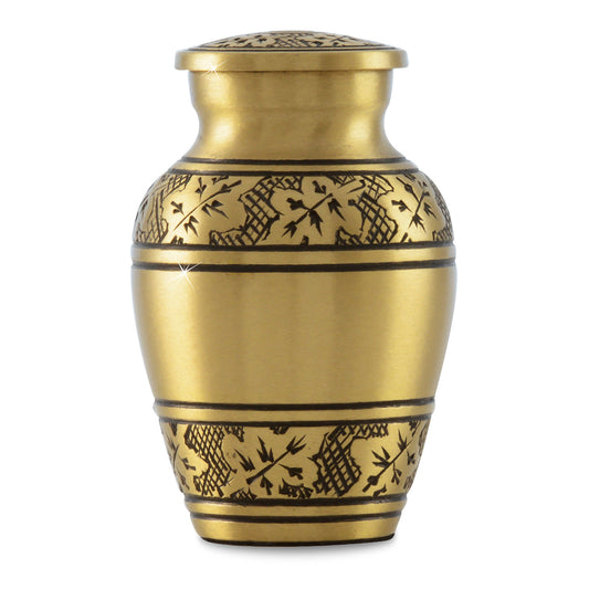 Small brass keepsake urn with a raised maple leaf on the front face