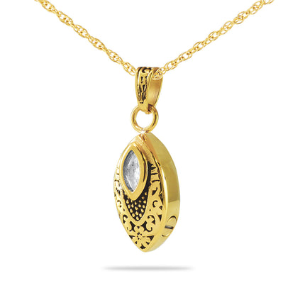 Gold cremation pendant set with a round clear crystal at the center of a polished charm