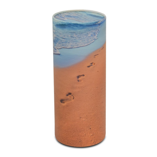 Tall biodegradable cylinder urn printed with footprints across pale sand