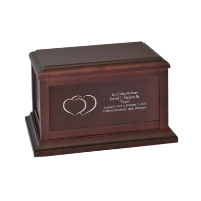 Wide wooden cremation urn with two hearts carved side by side on the front panel