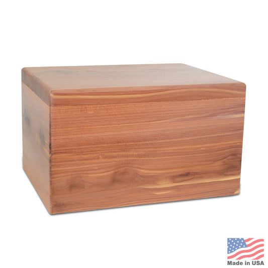 Low rectangular cedar cremation urn with reddish grain and clean unadorned edges