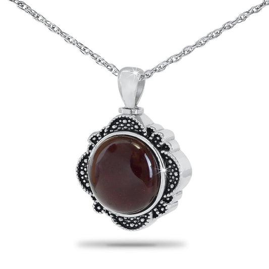 Polished steel keepsake urn with a deep red glass cabochon set into the front
