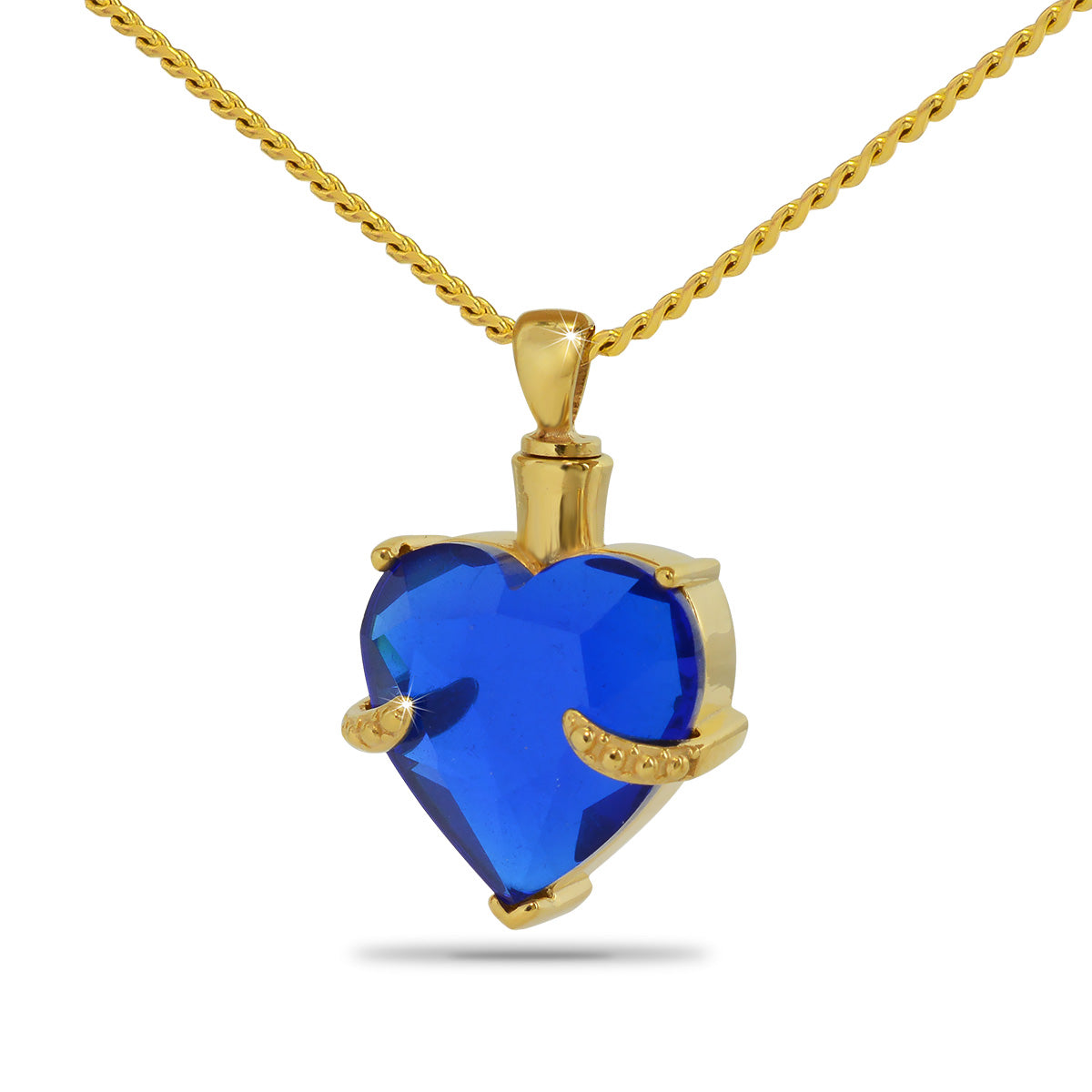 Gold-toned steel pendant set with a domed aqua blue glass stone, one inch across
