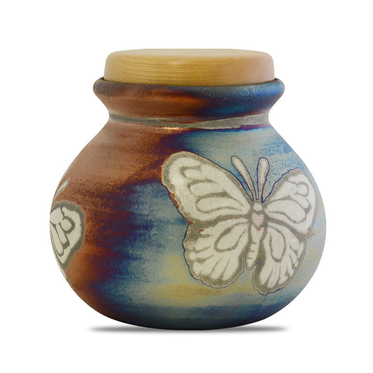 Round raku ceramic keepsake urn with a butterfly motif on a crackled smoke-fired glaze