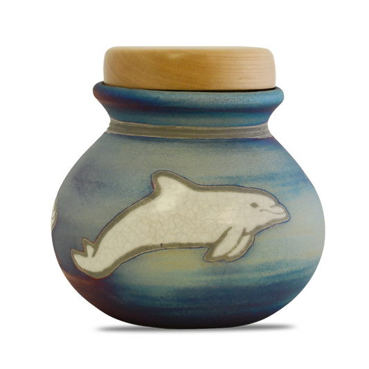 Round raku ceramic keepsake urn with dolphin motif over a crackled iridescent glaze
