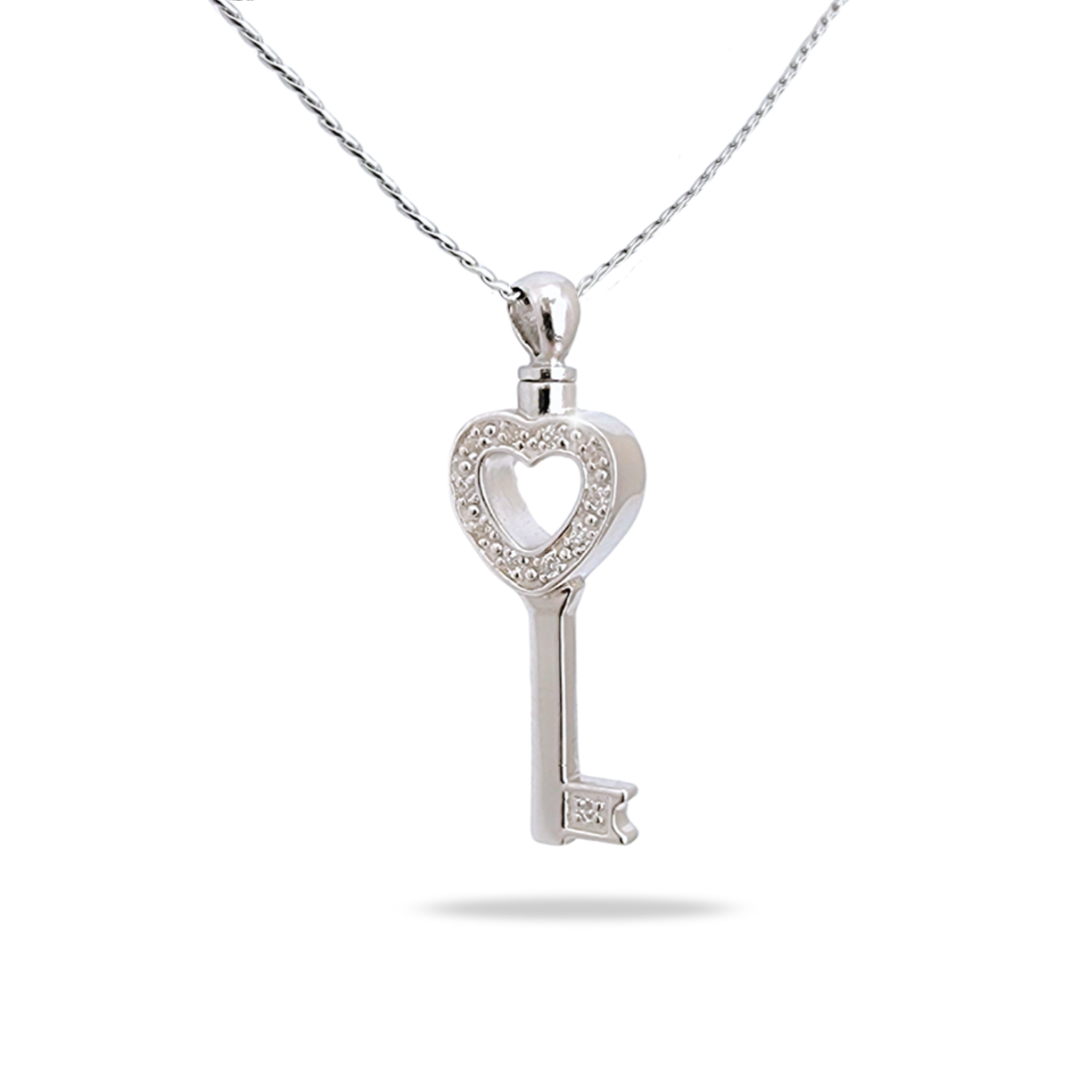 Silver key-shaped cremation pendant with an ornate bow, hanging on a silver chain