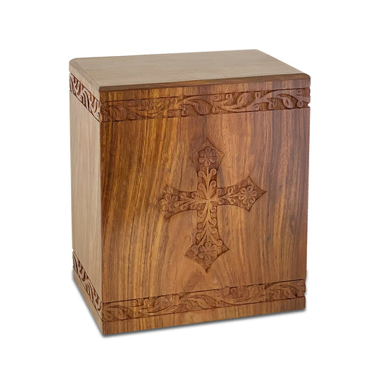 Wood cremation urn with a raised cross on the front panel and visible natural grain