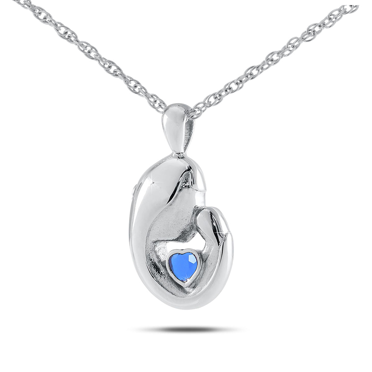 Upright silver pendant with a dark blue sapphire set near the top of the face
