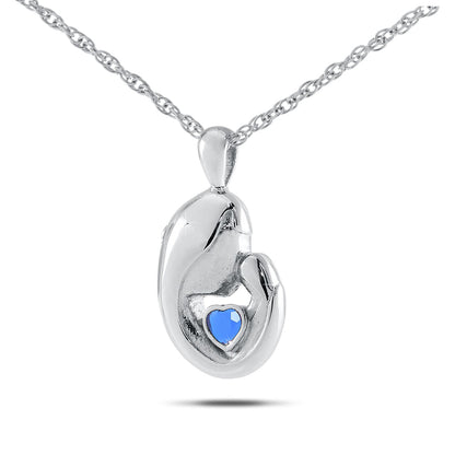 Upright silver pendant with a dark blue sapphire set near the top of the face