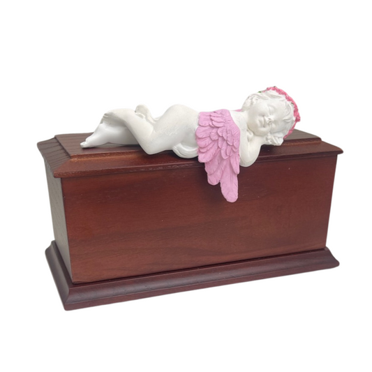 Wooden baby urn finished in pale pink with a sleeping angel carved across the top