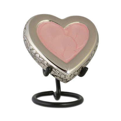 Soft pink heart keepsake urn with brass visible around the outer rim