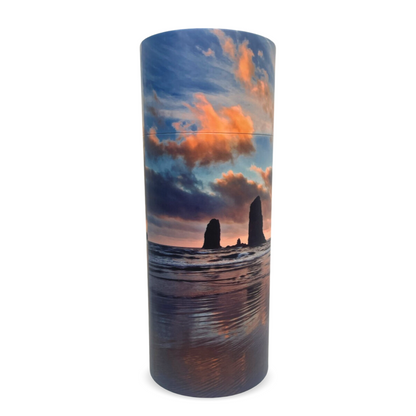 Tall biodegradable cylinder urn printed with smooth river rocks seen through clear water